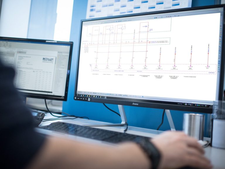 Person arbeitet an einem Computer mit CAD-Software für technische Zeichnungen.